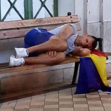 OBOSEALĂ MARE, MONȘER: Suporter român pozat dormind pe o bancă în Viena cu steagul la cap și berea la picioare